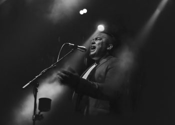 Microphone on stage greyscale. Original public domain image from Wikimedia Commons