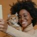 studio photo of diversity person with pet is making selfie on neutral background --chaos 10 --ar 3:2 Job ID: 2f448837-b24c-4466-88f1-c6dde264be21