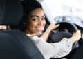 Afro Woman Driver Buying New Car Doing Test Drive Choosing New Auto In Dealership Store. Selective Focus