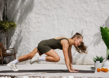 Athletic woman performing mountain climbers during HIIT workout at home outdoor gym functional training for healthy lifestyle