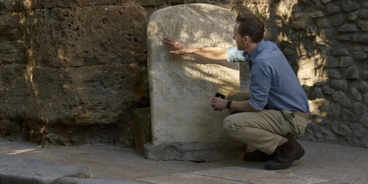 Tom Hiddleston examines an inscription at the Gatehouse ruins in Pompeii. (National Geographic/Paolo Verzone)