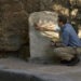 Tom Hiddleston examines an inscription at the Gatehouse ruins in Pompeii. (National Geographic/Paolo Verzone)