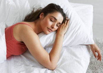 Top view of beautiful young woman sleeping while lying in bed