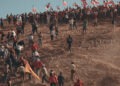 People climb a hill in a crowd waving Chilean flags. (credit: Miguel Soffia)