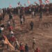 People climb a hill in a crowd waving Chilean flags. (credit: Miguel Soffia)