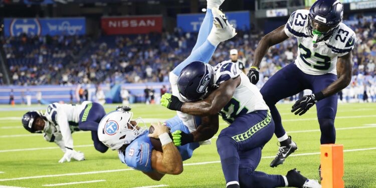 NASHVILLE, TENNESSEE - AUGUST 23: Will Levis #8 of the Tennessee Titans is tackled by D'Anthony Bell #23 and Aaron Smith #42 of the Seattle Seahawks during the second half of Week 2 of the preseason game at Nissan Stadium on August 23, 2026 in Nashville, Tennessee. (Photo by Johnnie Izquierdo/Getty Images)
