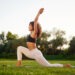 Warrior yoga exercise. Young fitness woman is on the field outdoors.
